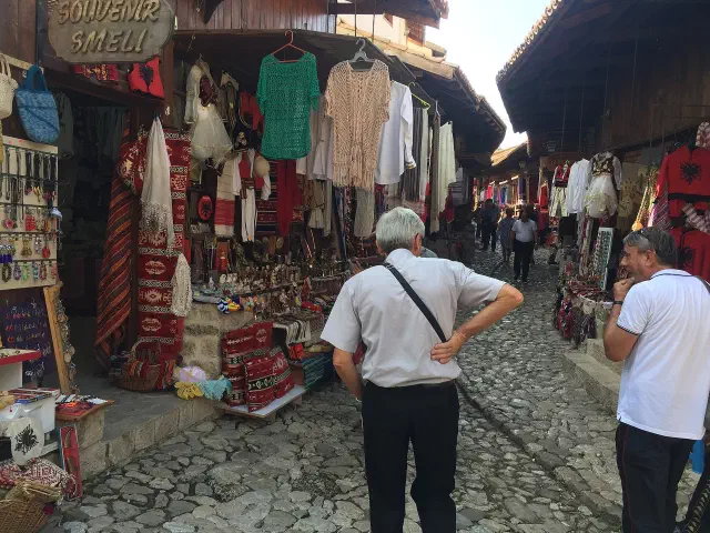 De oude bazaar van Krujë met souvenirwinkels en wollen kleden langs het geplaveide straatje