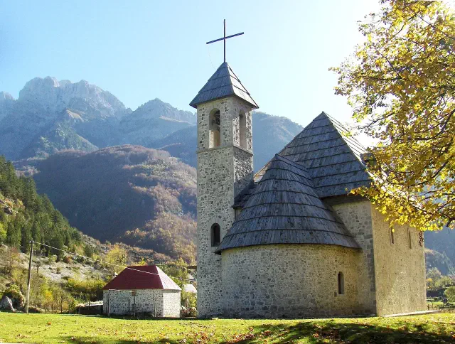 Het stenen kerkje van Theth uit 1892 met alpendak midden in de groene Shala-vallei Het stenen kerkje van Theth uit 1892 met alpendak midden in de groene Shala-vallei